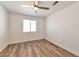 Minimalist bedroom featuring sleek floors, a ceiling fan, and a large window with natural light at 9748 Derbyhill Cir, Las Vegas, NV 89117