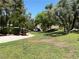 Lush green space with mature trees and a walking path leading to a covered bridge in a serene outdoor setting at 9748 Derbyhill Cir, Las Vegas, NV 89117