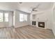 Bright living room featuring a fireplace, wood-look floors, and a large window for ample natural light at 9748 Derbyhill Cir, Las Vegas, NV 89117