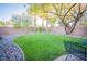 Beautiful backyard featuring green grass and river rock with a view of palm trees at 10391 Avebury Manor Ln, Las Vegas, NV 89135