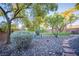 Landscaped backyard with river rock, trees and green grass at 10391 Avebury Manor Ln, Las Vegas, NV 89135