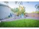 Green backyard featuring a playhouse, river rock accents, and trees at 10391 Avebury Manor Ln, Las Vegas, NV 89135