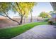 Well-maintained backyard featuring lush green grass, mature trees, and a paved patio area at 10391 Avebury Manor Ln, Las Vegas, NV 89135