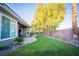 Backyard featuring a paved patio with seating, lush green grass and mature trees for shade and privacy at 10391 Avebury Manor Ln, Las Vegas, NV 89135