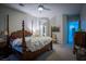 Bedroom with four-poster bed, ceiling fan, and multiple doorways at 10391 Avebury Manor Ln, Las Vegas, NV 89135