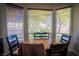 Cozy breakfast nook with natural light from large windows, surrounded by trees and lush greenery at 10391 Avebury Manor Ln, Las Vegas, NV 89135