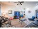 Cozy living room with hardwood floors, a large TV, lots of natural light and plenty of seating at 10391 Avebury Manor Ln, Las Vegas, NV 89135