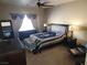Cozy bedroom featuring neutral carpet, soft natural light, and ceiling fan at 10548 Ettenmoor Ave, Las Vegas, NV 89135