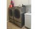 Modern laundry room with gray front loading washer and dryer with white cabinets at 10548 Ettenmoor Ave, Las Vegas, NV 89135