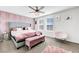 Stylish main bedroom with a paneled accent wall, ceiling fan and ensuite bathroom at 1125 Meadow Sparrow Pl, Henderson, NV 89011