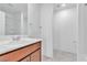 Bathroom sink with brown cabinets, white countertop and mirror, plus shower access at 1145 Belton Lake Ave, North Las Vegas, NV 89086