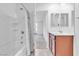 Bathtub with neutral shower curtain, double vanity, and view to bedroom at 1145 Belton Lake Ave, North Las Vegas, NV 89086