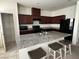 Features granite countertops, dark wood cabinets, stainless steel sink, and a breakfast bar with seating at 1145 Belton Lake Ave, North Las Vegas, NV 89086