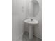 Clean and simple powder room featuring a pedestal sink, round mirror, and neutral-toned walls at 1145 Belton Lake Ave, North Las Vegas, NV 89086