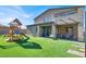 Backyard with artificial turf, playground, hanging chair swings and covered dining area at 1297 Ventura Cliffs Ave, Henderson, NV 89012