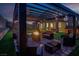 Cozy backyard patio with a fire pit, ample seating, and overhead string lights at 1297 Ventura Cliffs Ave, Henderson, NV 89012