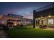 Backyard at dusk featuring green lawn, outdoor seating area, playhouse and swing set at 1297 Ventura Cliffs Ave, Henderson, NV 89012
