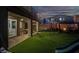 Backyard featuring a covered patio, artificial grass, play areas, and hanging chair swings at 1297 Ventura Cliffs Ave, Henderson, NV 89012