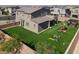 Large backyard with artificial grass, play structure, covered patio, and privacy fence at 1297 Ventura Cliffs Ave, Henderson, NV 89012