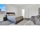 Bright bedroom features a cozy gray bed frame, plush rug, and comfortable seating area at 1297 Ventura Cliffs Ave, Henderson, NV 89012