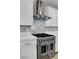 Close-up of a stainless steel range with a modern vent hood and white cabinets at 1297 Ventura Cliffs Ave, Henderson, NV 89012