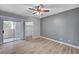 This bedroom boasts a ceiling fan, wood-look floors, and a sliding glass door to a balcony at 1501 Oscar Ct # 101, Las Vegas, NV 89146