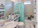 Bright bathroom featuring a tub with shower, tiled walls, storage shelves, and decorative accents at 1569 Hialeah Dr, Las Vegas, NV 89119