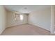 A spacious bedroom with neutral carpeting and a window providing natural light at 1569 Hialeah Dr, Las Vegas, NV 89119