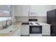 Functional kitchen featuring an oven, sink, microwave and upper and lower white cabinets at 1569 Hialeah Dr, Las Vegas, NV 89119