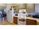 Functional kitchen with white appliances and wooden cabinets; perfect for home cooking at 1569 Hialeah Dr, Las Vegas, NV 89119