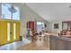 Bright living room with vaulted ceilings, stylish furniture, and eye-catching yellow front door at 1808 Piccolo Way, Las Vegas, NV 89146