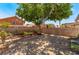 The cozy backyard has a brick patio, surrounded by a cinder block wall for privacy and an established tree for shade at 1922 Falcon Ridge St, Las Vegas, NV 89142