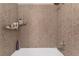 Shower featuring brown tiles, a showerhead, and assorted soaps and shampoos at 1922 Falcon Ridge St, Las Vegas, NV 89142