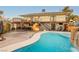 Expansive backyard with a pool, rock waterfall, patio and exterior staircase to the second floor balcony at 200 E Desert Rose Dr, Henderson, NV 89015