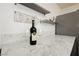 Close up of wine glasses and bottle on white marble counter in bar area at 200 E Desert Rose Dr, Henderson, NV 89015