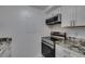 Close-up of kitchen with granite counters and stainless stove and microwave at 205 E Harmon Ave # 112, Las Vegas, NV 89169