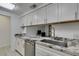 White cabinets with granite countertops and stainless dishwasher and sink at 205 E Harmon Ave # 112, Las Vegas, NV 89169
