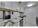 A clean galley kitchen with stainless appliances, granite countertops and white cabinets at 205 E Harmon Ave # 112, Las Vegas, NV 89169