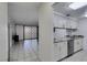A spacious kitchen leading into the light-filled living room with tile floors at 205 E Harmon Ave # 112, Las Vegas, NV 89169