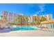 Community swimming pool with lounge chairs in front of high-rise buildings at 205 E Harmon Ave # 112, Las Vegas, NV 89169