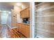 Hallway kitchenette with wood cabinets, granite counters, and a view of the pantry with metal shelving at 2319 Little Italy Ave, North Las Vegas, NV 89031