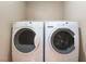 Convenient laundry room with modern side-by-side washer and dryer units and shelving at 2319 Little Italy Ave, North Las Vegas, NV 89031