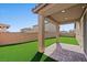 Backyard area with well-maintained artificial turf and a covered patio at 3708 Fuselier Dr, North Las Vegas, NV 89032