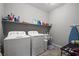 Well-equipped laundry room with washer, dryer, shelving, and utility sink at 3708 Fuselier Dr, North Las Vegas, NV 89032