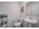 Cozy powder room featuring a pedestal sink, toilet, and ornate metal shelving unit at 387 Larksong Ave, Henderson, NV 89011