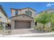 Two-story home featuring desert landscaping, a two-car garage, and beautiful exterior accents at 387 Larksong Ave, Henderson, NV 89011
