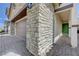 Close-up of a home's stone facade, a two-car garage, and a green front door at 387 Larksong Ave, Henderson, NV 89011