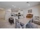 Open-concept kitchen with island seating and stainless appliances flowing into a dining area with a rustic hutch at 387 Larksong Ave, Henderson, NV 89011