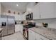Modern kitchen features stainless steel appliances, granite countertops, and white cabinetry at 387 Larksong Ave, Henderson, NV 89011