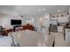 A modern open-concept living space featuring an island kitchen with an open living area with a wall-mounted television at 387 Larksong Ave, Henderson, NV 89011